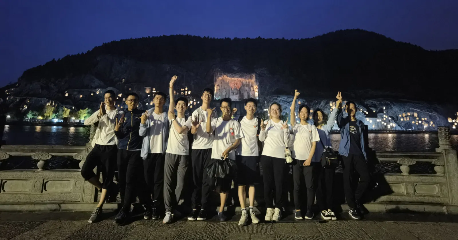 夜里,十一人在龙门石窟对岸举手欢呼