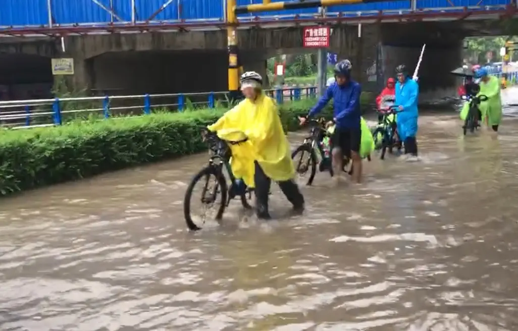 队员推着车蹚过积水的路口