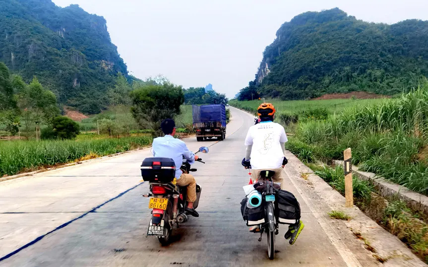 两名队员在石山间的水泥路上骑行