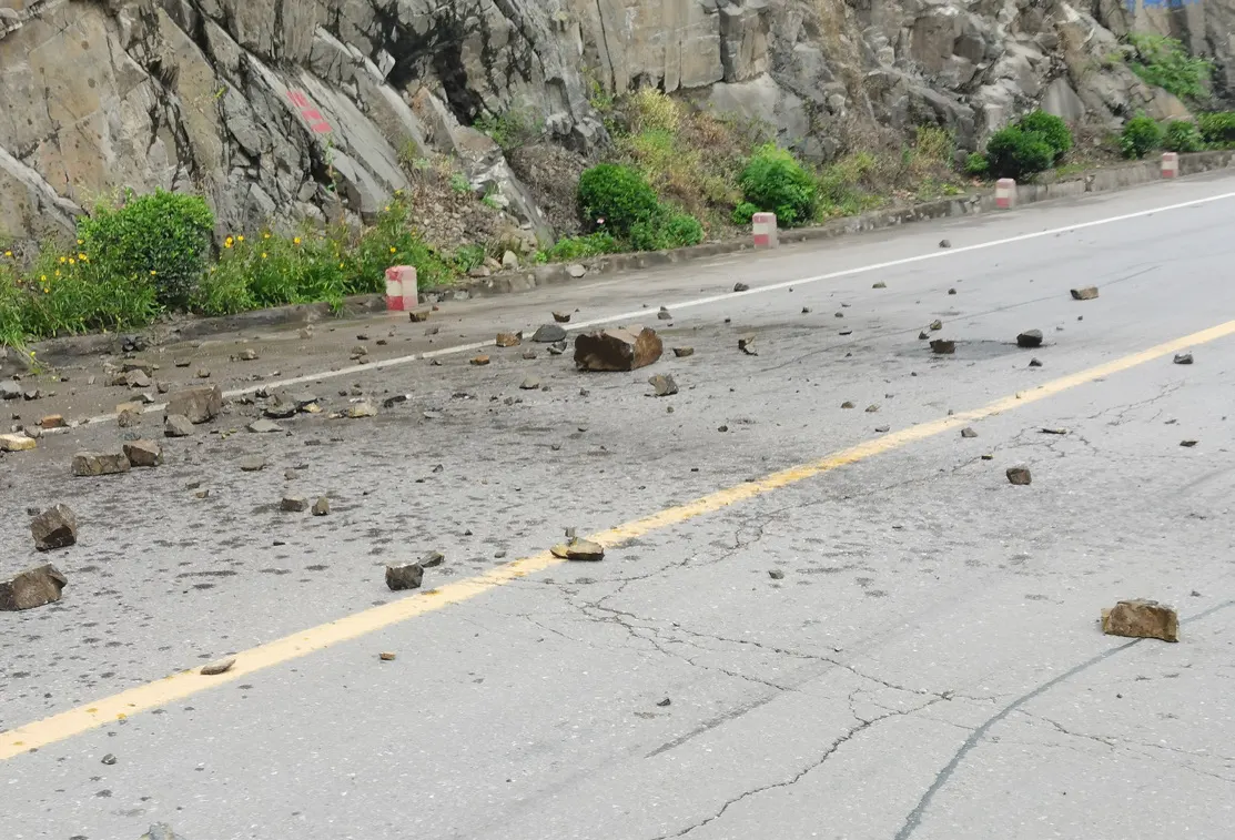 落石散落在山脚的公路上