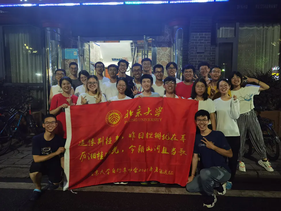 夜里,两团队员在客栈门前举着红旗合影
