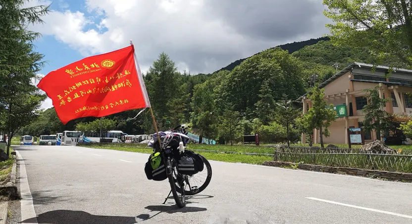 插着红旗的自行车停在山间公路边
