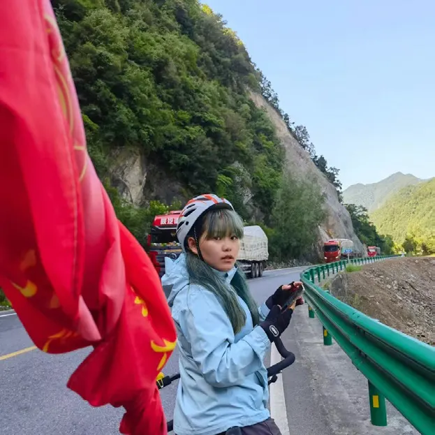 dudu 扛着红旗走在山路上