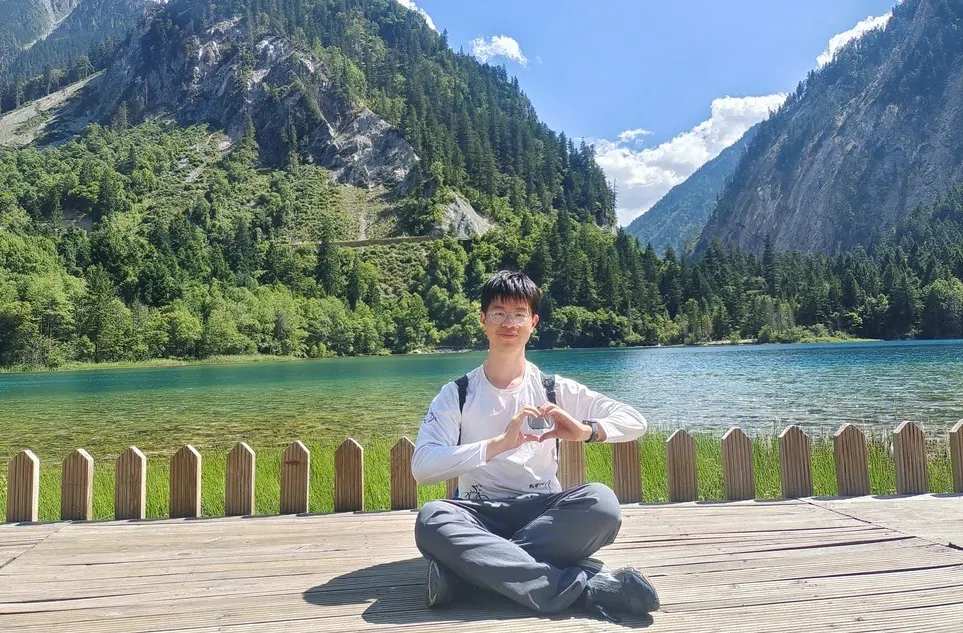 华年盘腿坐在雪山下的湖边