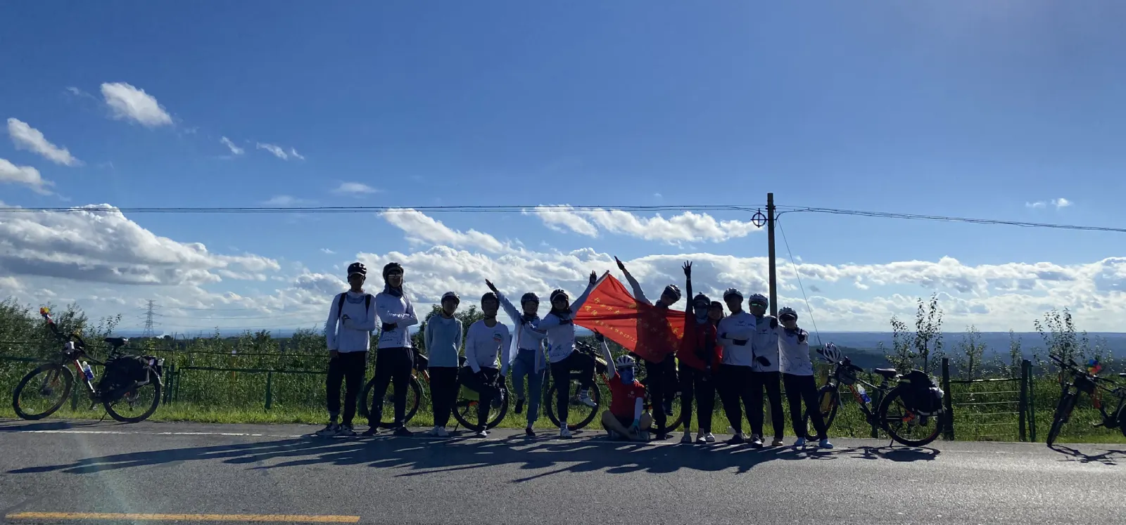 团员们沿路边排开举旗合影
