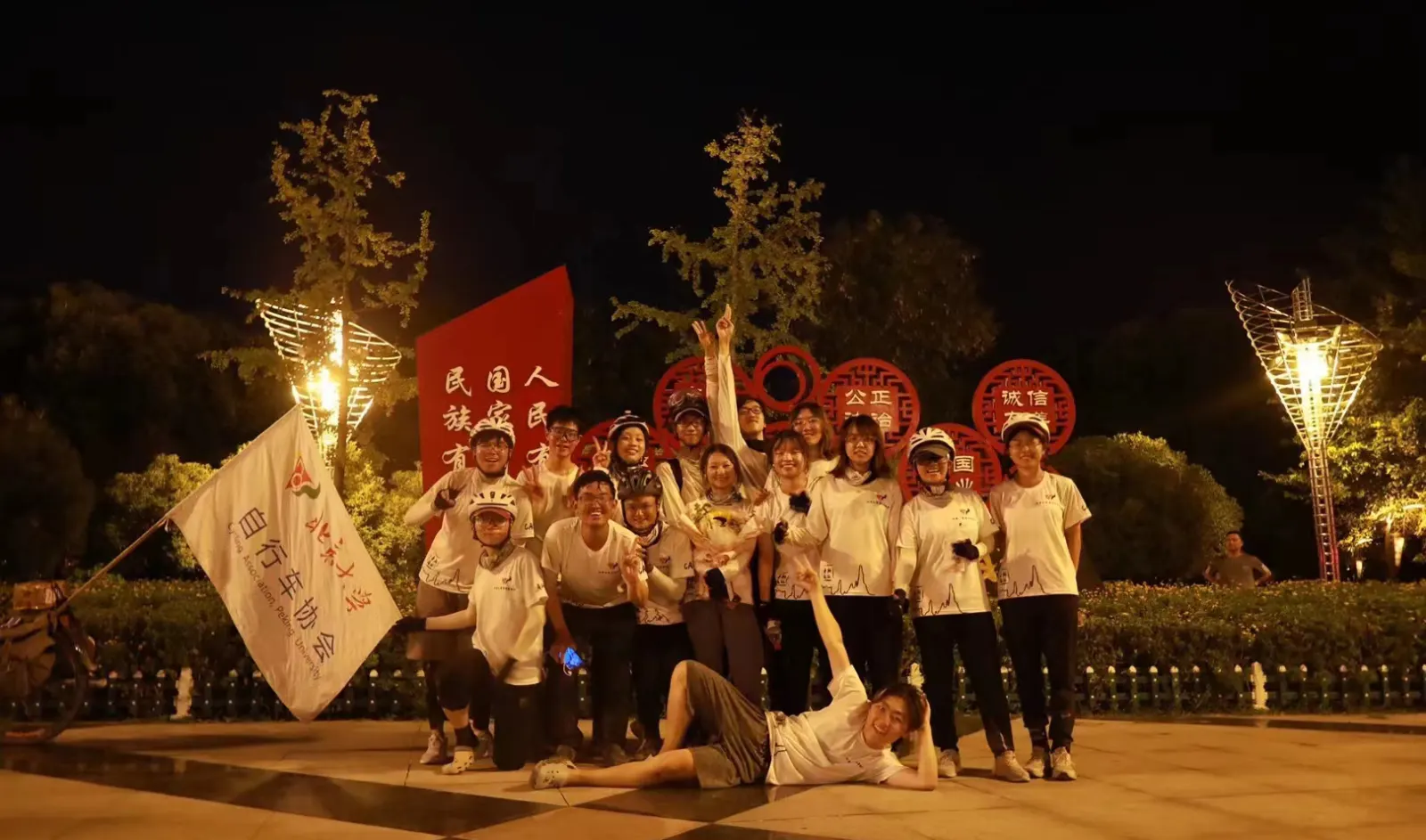 夜里团员们举着旗子合影